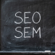 SEO vs SEM pissarra Pissarra amb SEO i SEM escrits, conceptes de màrqueting digital